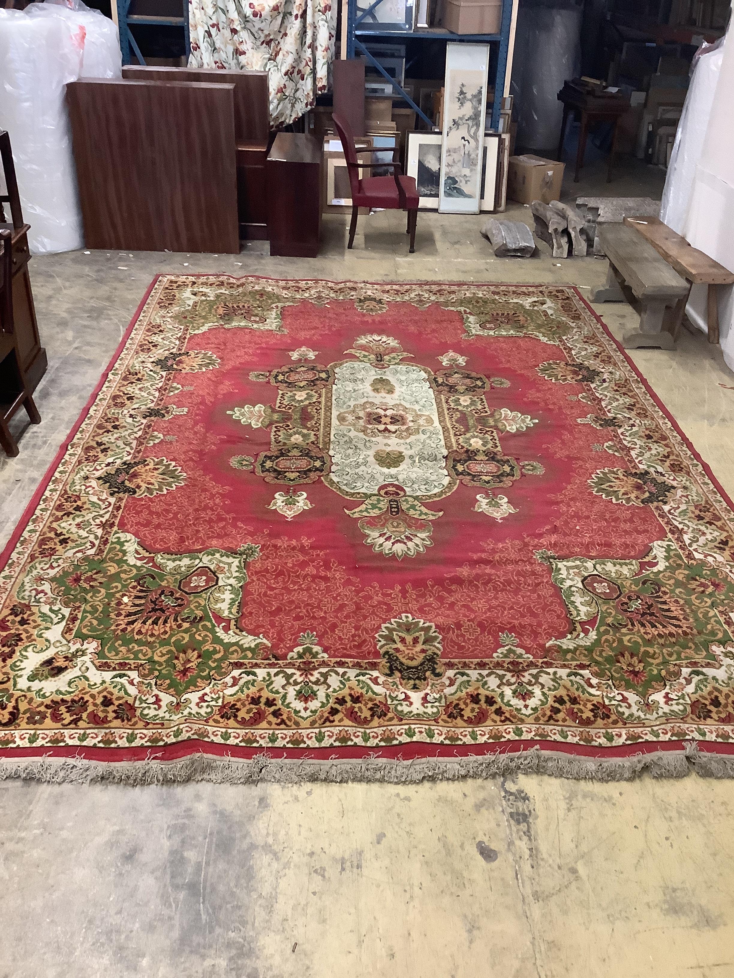 An Indian style machined red ground carpet, approx. 440 x 290cm